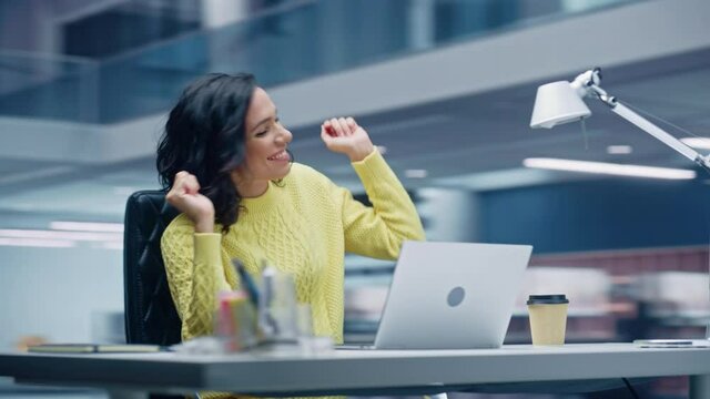 360 Degree Office: Smiling Hispanic Businesswoman Sitting at Desk Working on Computer, Dances while Listening Music. Latin Female Entrepreneur is Happy, Joyful, having Fun. Moving Around Tracking Shot