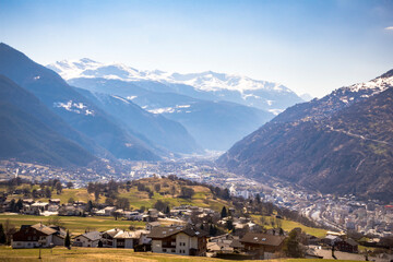 Fototapeta premium Green valley with some houses between the snowed mountains in center Switzerland, Europe 