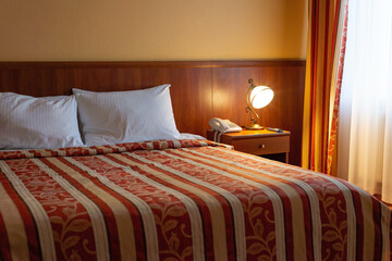 hotel bed interior with lamps in warm colors