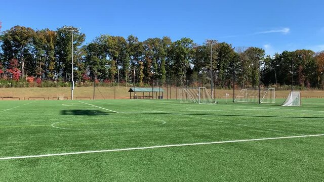 Pan across an empty soccer field on a Carolina blue sky day in autumn