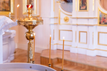 Fototapeta na wymiar christening bath and the altar at the orthodox church during christening.baptismal font. Accessories for the christening of children icons of candles