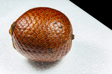 Ripe Buriti fruit (Mauritia flexuosa) isolated in selective focus with an emphasis on the scaly texture of the skin