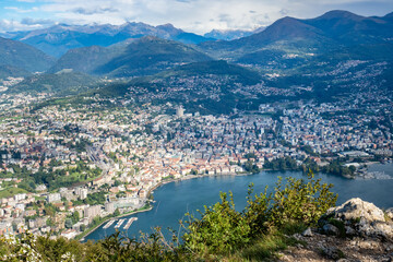 Fototapeta na wymiar Lugano, Switzerland - October 6th 2021: View from Monte San Salvatore towards the city surrounded by mountains