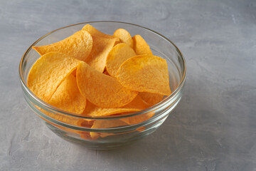 potato chips in a bowl on grey background unhealthy snack