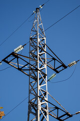 electrical network circuit steel tower with wires against clear blue sky background