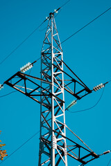 electrical network circuit steel tower with wires against clear blue sky background