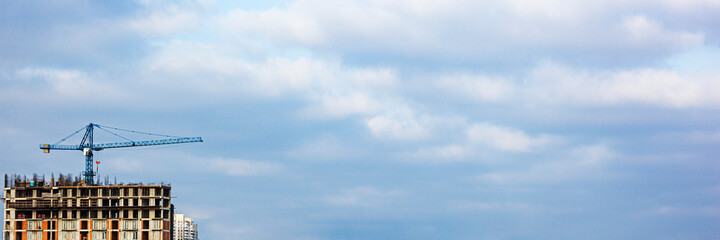 Inside place for tall buildings under construction and cranes under a blue sky