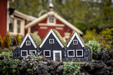 Three black elf houses. Small hand-made wooden homes for elves as a garden decoration in front of a...