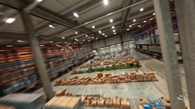FPV aerial flight inside warehouse. Huge storage industrial building stockhouse with delivery goods. Logistics concept. Speed drone views.