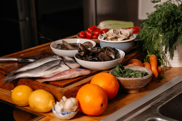 Sea bream and shells on the table next to vegetables and fruit. Ingredients for making a delicious...