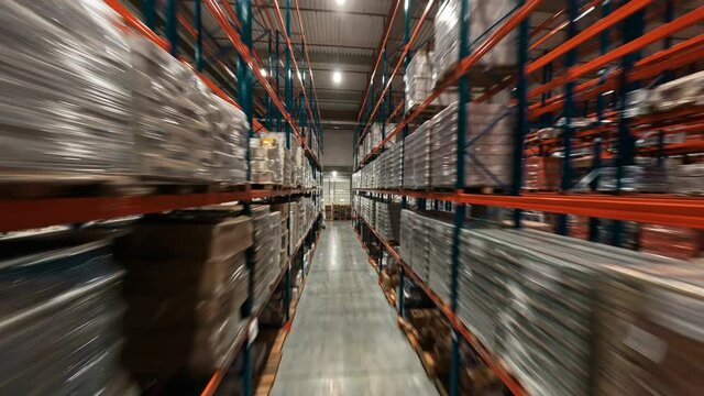Fast FPV drone flight in contemporary industrial retail warehouse. Large logistic park filled with delivery goods and transportation. Timelapse view.