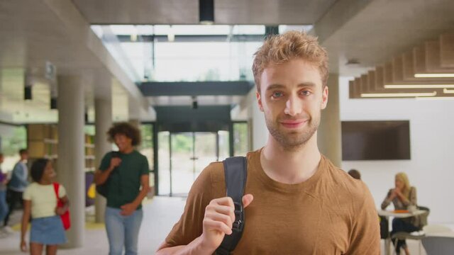 Portrait of male student in busy university or college building - shot in slow motion 