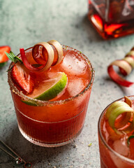 strawberry margarita with garnish, styled with strawberries, rhubarb and lime, close up
