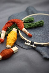 Wooden embroidery hoop. Embroidery set fot cross stitching. Grey fabric, colorful threads and embroidery hoop.