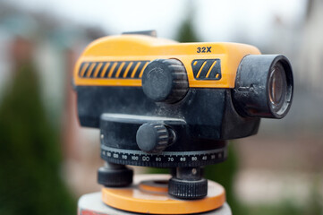 Surveying measuring equipment level transit on tripod at construction building area site