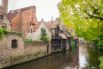 Fototapeta na wymiar Scenic view of old houses along a canal near Bonafacius Bridge in the historic town of Brugge, Belgium