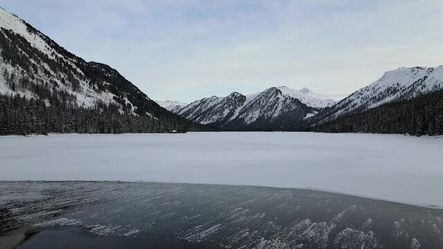 Aerial view of snow mountains and lake. Winter nature
