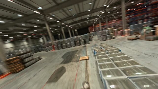FPV view inside industrial modern warehouse storage. Huge logistics park. Product distribution center building with delivery goods.