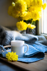 Obraz na płótnie Canvas Black coffee in white mug with elegant blue napkin and yellow flowers