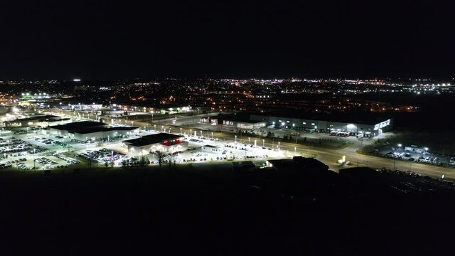 Close Up Zoom Towards Luxury Cars Dealership At Night Low Flying Aerial View