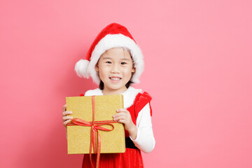 smiling young girl holding gift box stand in front of pink background