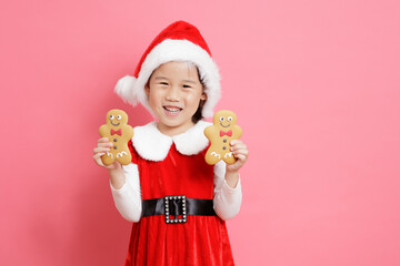 smiling young girl holding ginger bread  men stand in front of pink background