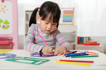 young girl drawing different shapes for homeschooling
