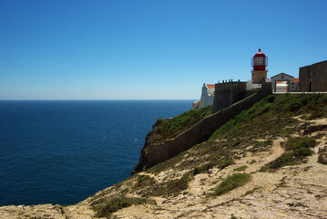 Fototapeta na wymiar Lighthouse at Sant Vincent cape, with calm blue ocean at the background