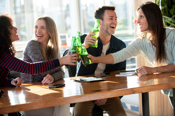 Smiling business people toasting bottles in office