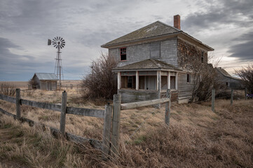 Abandoned farmhouse in rural alberta Canada with cloudy skies