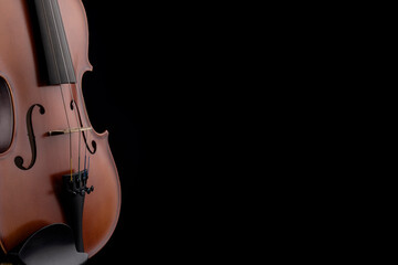 A part of a wooden violin or viola on a black background