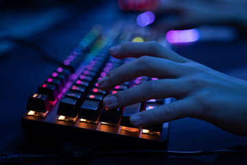 Cyber sport gamer holding hand at the computer keyboard while playing - obrazy, fototapety, plakaty