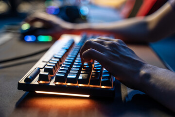 Unrecognizable man playing or streaming at the tournament at the internet cafe