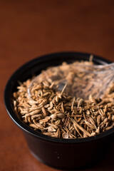 Some little cumin seeds in pot with a little plastic spoon in a grain storage 