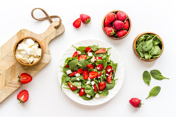 Fresh vegetarian green salad with strawberries and cheese, top view