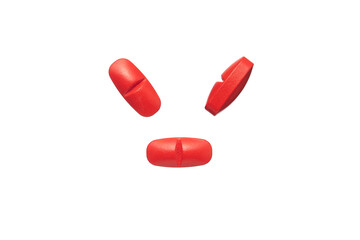 Red oval pills isolated on white background.