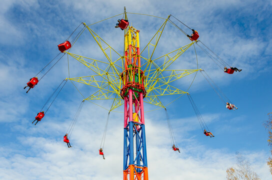 People ride on a round carousel at the top of the tower.