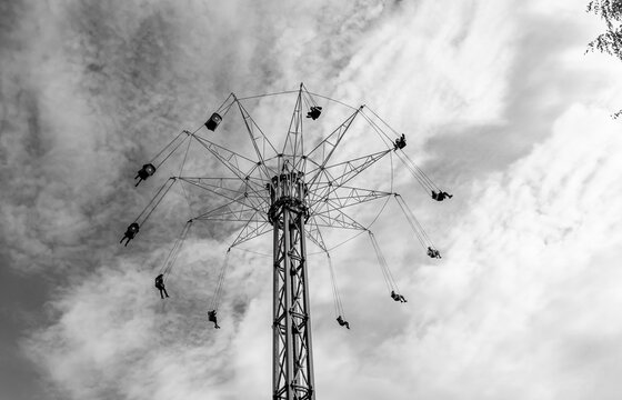 People ride on a round carousel at the top of the tower.