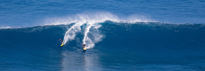 Surfing giant waves in the blue water of Maui Hawaii - Powered by Adobe
