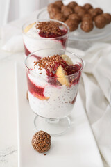 Tasty dessert with flax seeds and yoghurt in glass on white background