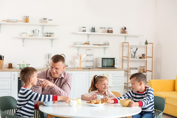 Happy father with his little children spending time together at home