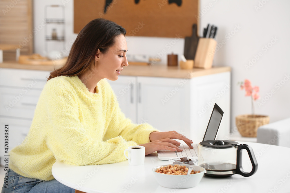 Wall mural morning of beautiful woman with laptop drinking coffee at home