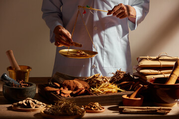 Traditional chinese medicine with herb and spices in brown wooden background and a doctor for...