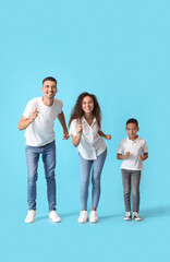 Happy dancing interracial family on color background
