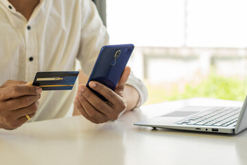 girl holding credit card and using phone Online shopping E-commerce Internet banking concept of spending money