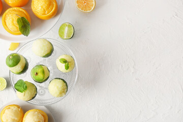 Plates with tasty ice creams in citrus fruit peels on light background - obrazy, fototapety, plakaty