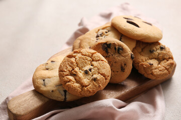Wooden board with tasty homemade cookies on white background