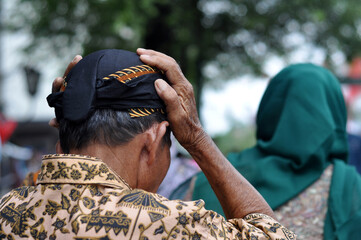 Domestic tourists are trying Blangkon in Malioboro Yogyakarta, Blangkon is a traditional hat from...