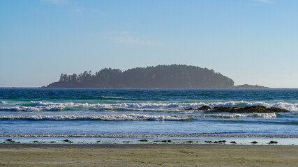 Looking to Pacific Ocean and island, listen to waves at Tofino beach during summer road trip in Vancouver Island