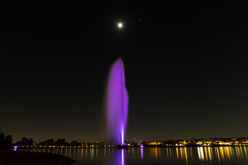 fountain at night in a city lit backdrop